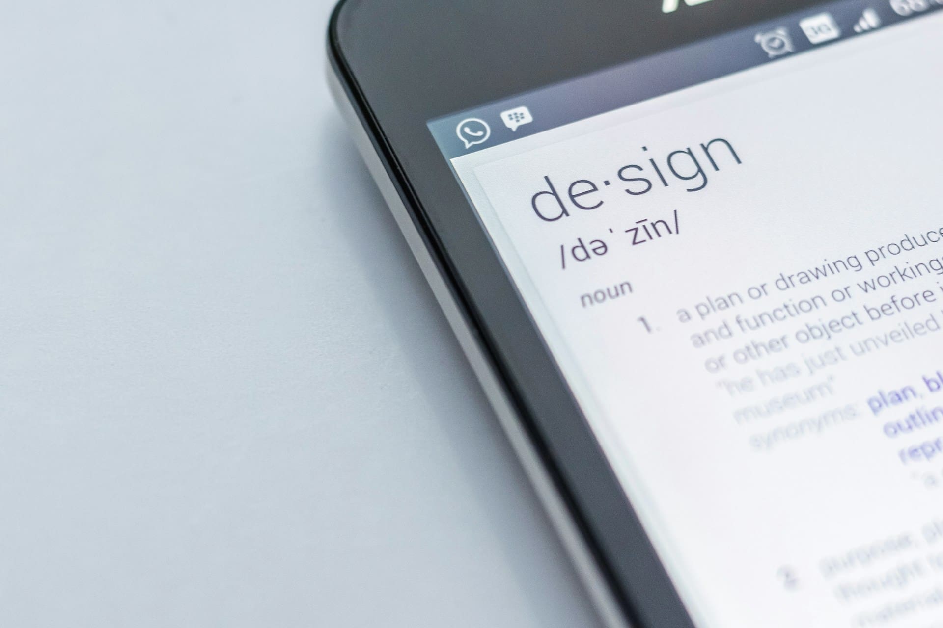 Picture of the corner of an iPhone with the definition and pronunciation of design